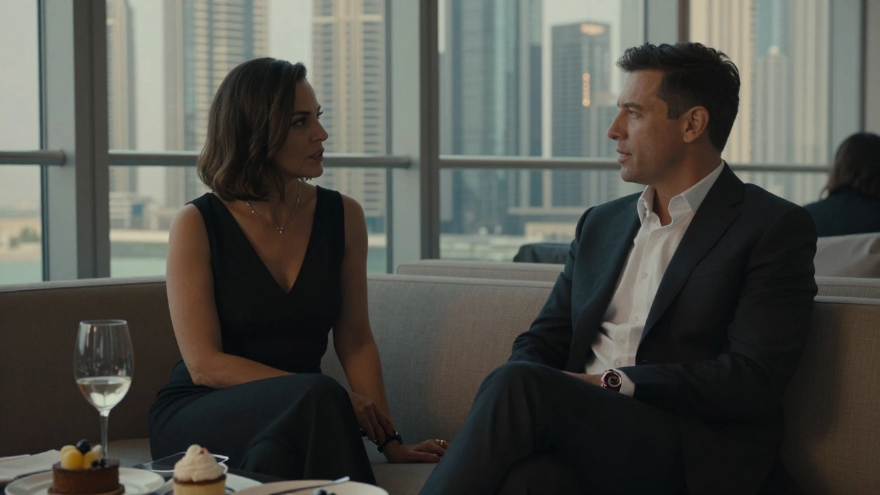 A mature woman listening attentively to a man in a private rooftop lounge, skyline visible through large windows.